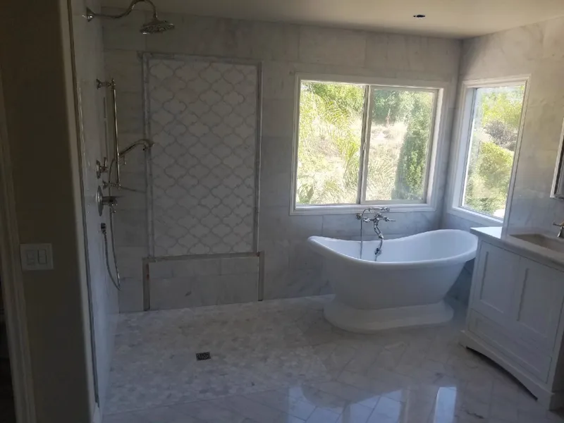 Bath with a freestanding tub, a tiled walk in shower and a marble look floor
