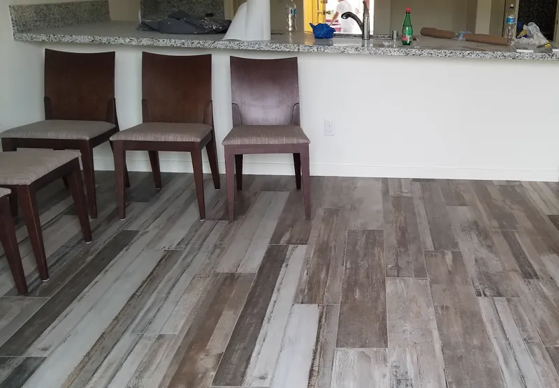 Gray and brown wood look plank floor under a granite breakfast bar