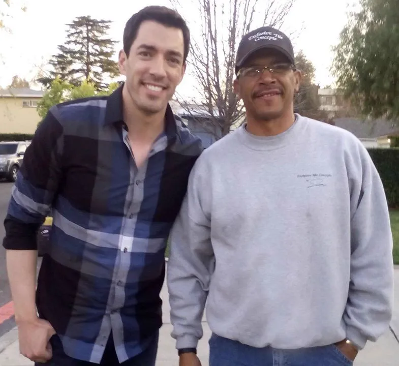 Jonathan Burton standing beside Jonathan Scott outside a house